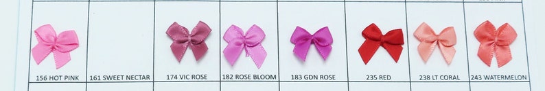 May include: A selection of ten satin ribbon bows in various shades of pink and red, including hot pink, sweet nectar, vic rose, rose bloom, gdn rose, red, lt coral, and watermelon.
