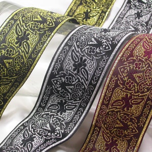 May include: Three different trims with black fabric and gold metallic accents. The trims have a paisley-like pattern.