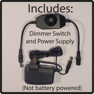 Puede incluir: Un juego de interruptor de atenuaci&oacute;n y fuente de alimentaci&oacute;n negros. El juego incluye un interruptor de atenuaci&oacute;n con un dial de encendido/apagado, un adaptador de corriente y cables de conexi&oacute;n. El texto de la imagen dice "Includes: Dimmer Switch and Power Supply (Not battery powered)".