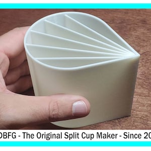 Pode incluir: Um porta-copos de plástico branco com seis compartimentos. O porta-copos é dividido em seções que podem ser dobradas juntas. O porta-copos está sendo segurado em uma mão.