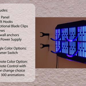 May include: A black lightsaber wall mount with a blue LED panel. The mount has four hooks for hanging lightsabers. The text on the image reads: 'Includes: LED Panel, 4 Hilt Hooks, 2 Optional Blade Clips, Screws, Drywall anchors, 12v Power Supply, Single Color Options: Dimmer Switch, Remote Color Option: Remote Control with color change choice and 300 animations.'