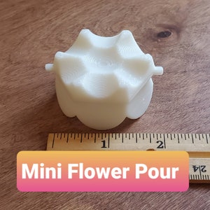 May include: White plastic flower pour with a 6-point star design. The pour is about 1 inch in diameter.