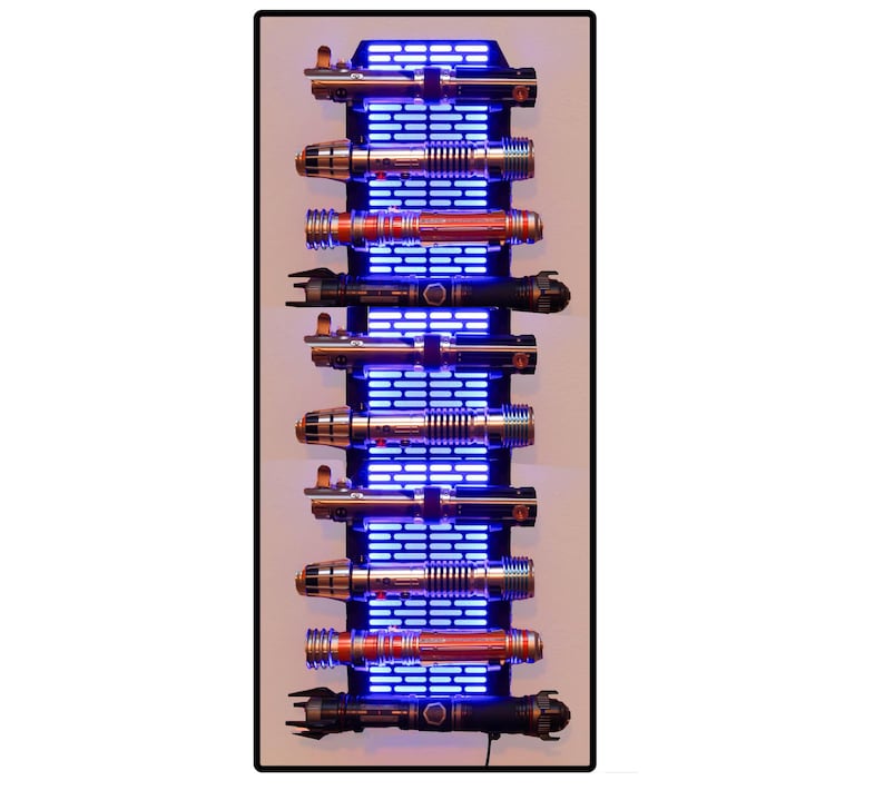 Puede incluir: Un expositor vertical con m&uacute;ltiples sables de luz. Los sables de luz son plateados, negros y rojos, montados en un marco negro con iluminaci&oacute;n LED azul. El expositor rectangular tiene un fondo blanco.