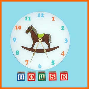 May include: A white clock with a rocking horse design and colorful numbers. The clock is surrounded by colorful wooden blocks that spell out the word "HORSE".