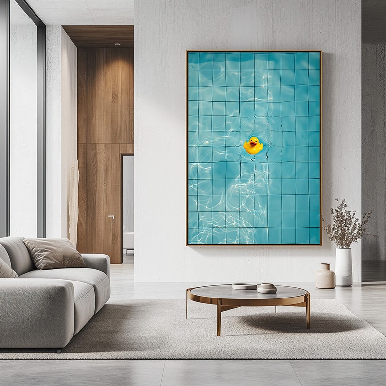 May include: A framed art print featuring a close-up view of a swimming pool with blue tiles and a yellow rubber duck floating in the water. The artwork is displayed in a modern living room setting.