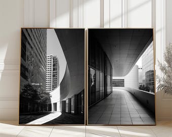 May include: Two framed black and white architectural prints. The left print shows a curved building facade with a skyscraper in the background. The right print depicts a long, curved walkway with a modern building.