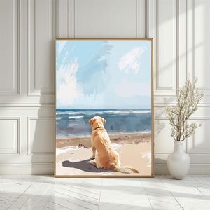 May include: A framed art print showing a yellow Labrador Retriever on a sandy beach, looking out to sea. The artwork features a blue sky with white clouds and the sea in shades of blue. The print is in a gold frame.
