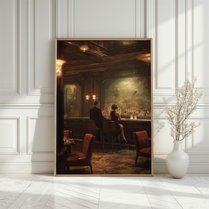 May include: A framed print depicts a vintage bar scene with a man and woman at the counter. The artwork features warm tones, with a focus on the bar's interior, including bottles, chairs, and lighting. The print is in a gold frame.