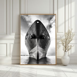 Może przedstawiać: Czarno-białe zdjęcie przodu dużego statku. Statek znajduje się w wodzie, a niebo jest pochmurne.