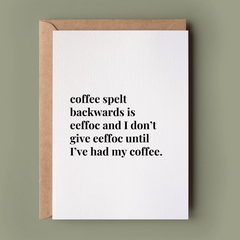 May include: A white greeting card with a brown envelope featuring black text that reads: coffee spelt backwards is eeffoc and I don't give eeffoc until I've had my coffee. The card has a clean, minimalist design with a simple serif font.