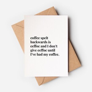 May include: A white greeting card with black text that reads: coffee spelt backwards is eeffoc and I don't give eeffoc until I've had my coffee. The card is placed on top of a light brown kraft paper envelope, creating a simple and clean contrast.