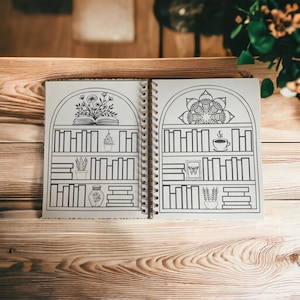 May include: A black and white illustrated journal with a spiral binding. The cover features a bookshelf with a book, plants, a cup of coffee, and a butterfly. The journal is open to a page with a mandala design.