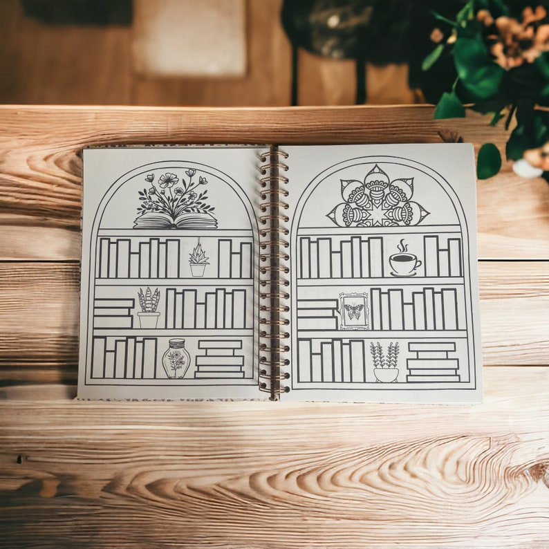 May include: A black and white illustrated journal with a spiral binding. The cover features a bookshelf with a book, plants, a cup of coffee, and a butterfly. The journal is open to a page with a mandala design.