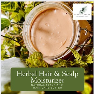 May include: A jar of herbal hair and scalp moisturizer. The product is a light brown color and is in a clear glass jar with a metal clasp. The text "Herbal Hair & Scalp Moisturizer" is displayed on a green background.