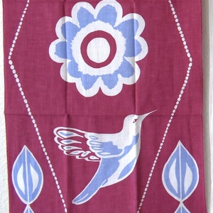 May include: A pink fabric panel with a white diamond pattern and blue and white floral and leaf designs. A white hummingbird with blue accents is centred in the diamond.