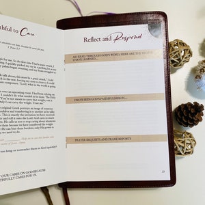 May include: A close-up of a brown leather-bound journal with a cream-colored page. The page has a section titled "Reflect and Respond" with the text "As I read through God's word, here are the truths I have learned..." and "I have seen God's faithfulness in..."  The page also has a section titled "Prayer Requests and Praise Reports".