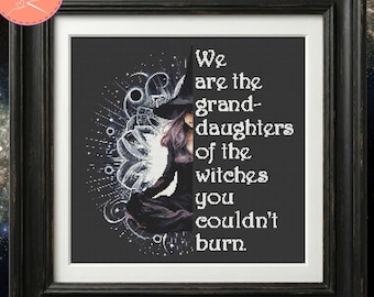 May include: A framed cross-stitch pattern featuring a dark silhouette of a witch wearing a pointed hat, set against a white mandala design. The text reads: We are the granddaughters of the witches you couldn't burn. The frame is black.