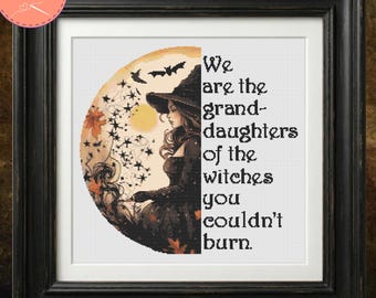 May include: A framed cross-stitch pattern featuring a witch in a pointed hat against a circular orange moon background with bats and stars. The text reads: We are the granddaughters of the witches you couldn't burn. The frame is black and square.