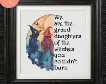 May include: A framed cross-stitch pattern featuring a crescent moon, two figures in pointed hats, and the text: We are the granddaughters of the witches you couldn't burn. The design uses blue, purple, and orange tones on a white background.