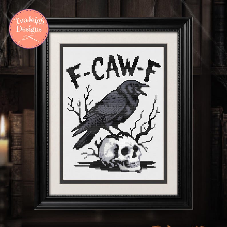 May include: Framed cross-stitch art featuring a black crow perched atop a skull, with the text "F-CAW-F" above. The artwork is in a black frame, perfect for Halloween or gothic decor.