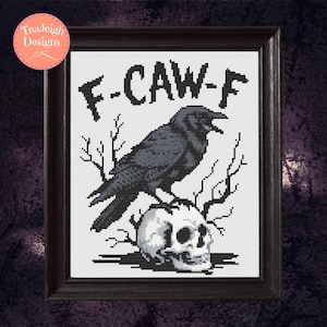 May include: Cross-stitch art in a dark wooden frame. The design features a black crow perched on a skull, with the text "F-CAW-F" above. The artwork has a gothic or Halloween theme.