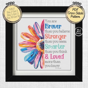 Könnte beinhalten: Ein gerahmtes Kreuzstichmuster mit einem farbenfrohen Halb-Gänseblümchen-Design. Der Text lautet: "You are Braver than you believe, Stronger than you seem, Smarter than you think & Loved more than you know." Enthält ein "PDF Cross Stitch Pattern"-Etikett.