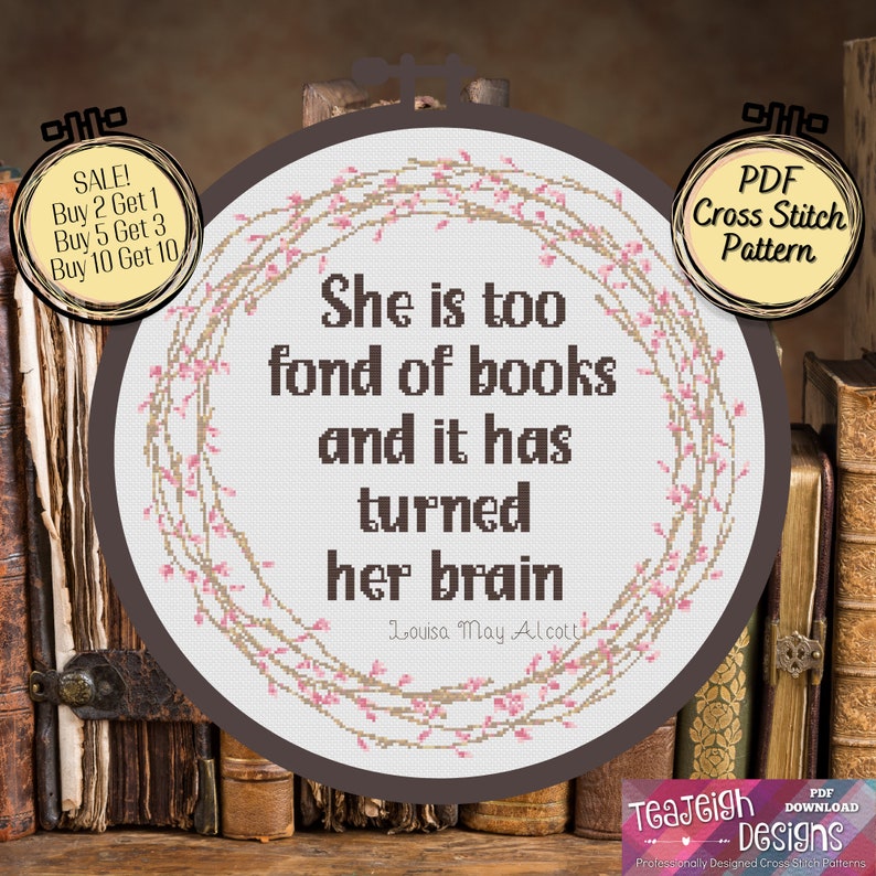 May include: A brown embroidery hoop with a white background and a pink floral design. The quote "She is too fond of books and it has turned her brain" is written in black text. The quote is attributed to Louisa May Alcott.