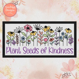 May include: Cross-stitch design featuring a row of colorful flowers in pink, yellow, blue, and purple. The phrase "Plant Seeds of Kindness" is stitched in purple below the flowers, all within a black rectangular frame.