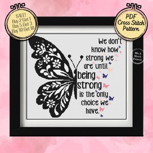 Könnte beinhalten: Ein gerahmtes Kreuzstichmuster mit einem schwarz-weißen Schmetterlingsdesign. Der Text lautet: "Wir wissen nicht, wie stark wir sind, bis Stärke die einzige Wahl ist." Enthält ein Etikett "PDF Cross Stitch Pattern".