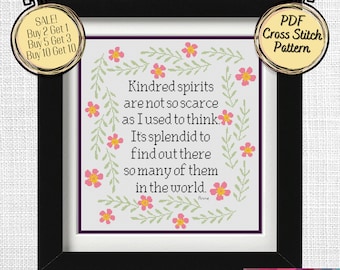May include: A black framed cross stitch pattern with a white background and pink flowers. The pattern features the quote "Kindred spirits are not so scarce as I used to think. It's splendid to find out there so many of them in the world. - Anne".