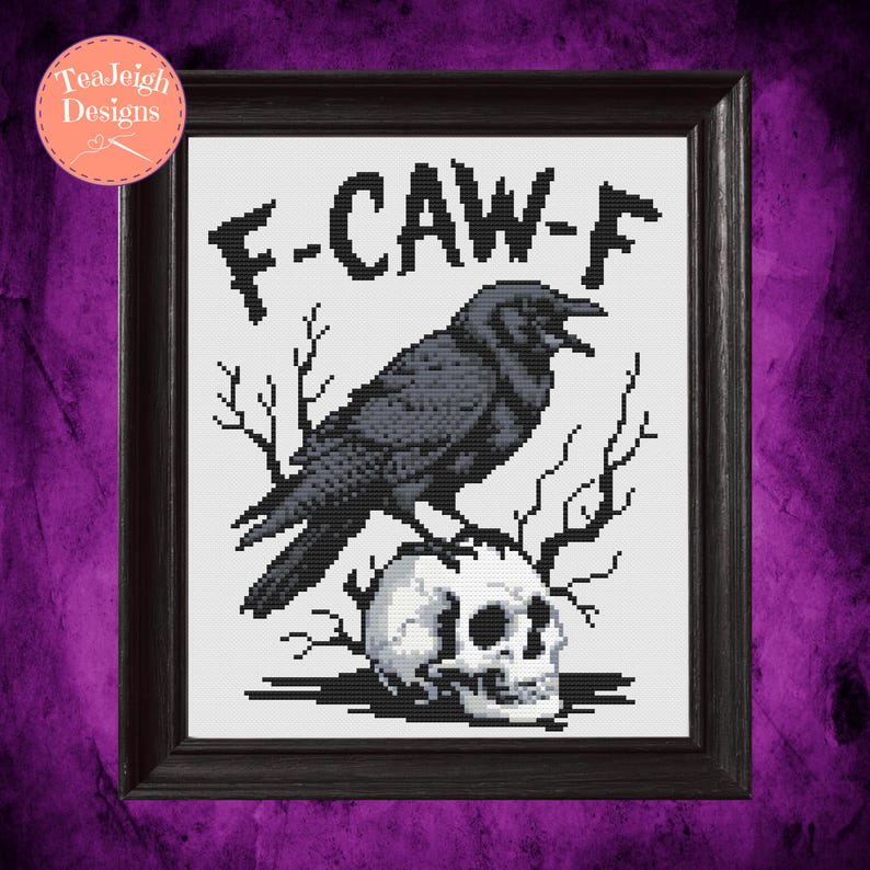 May include: Framed cross-stitch art featuring a black crow perched atop a skull, with the text "F-CAW-F" above. The artwork is set against a white background and framed in a dark wooden frame. The design has a gothic theme.