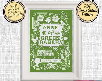 May include: A green cross stitch pattern featuring the title "Anne of Green Gables" with illustrations of a house, birds, flowers, and a teacup. The text "L.M. Montgomery" is also included.