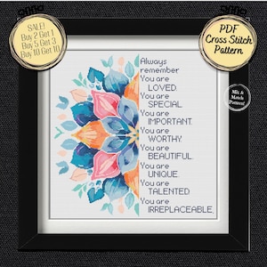 May include: A framed cross-stitch pattern with a floral design in shades of blue, orange, and pink. The text reads "Always remember You are LOVED, SPECIAL, IMPORTANT, WORTHY, BEAUTIFUL, UNIQUE, TALENTED, IRREPLACEABLE."