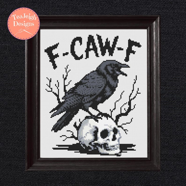 May include: Framed cross-stitch art featuring a black crow perched atop a skull. The artwork includes the text "F-CAW-F" in bold letters. The design is set against a white background and framed in a dark wood.