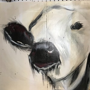 Op de afbeelding: Een close-up schilderij van een koeiengezicht, in zwart, wit en crème. Het oog van de koe is zichtbaar en het schilderij heeft een textuur, penseelstijl. Het kunstwerk is verdeeld over twee houten panelen.