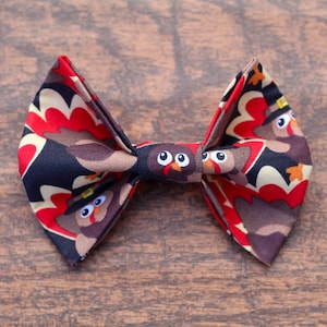 Turkey Dog Bow Tie with turkeys wearing Thanksgiving hats on brown background.