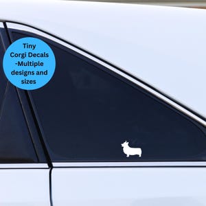 May include: White silhouette of a corgi dog on a black car window. The text "Tiny Corgi Decals -Multiple designs and sizes" is on a blue circle.