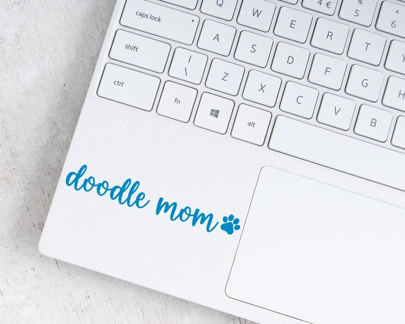 Blue Doodle Mom decal with a paw print placed on a laptop.