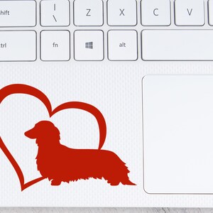 Red Long Haired Dachshund decal with a heart placed on a laptop.