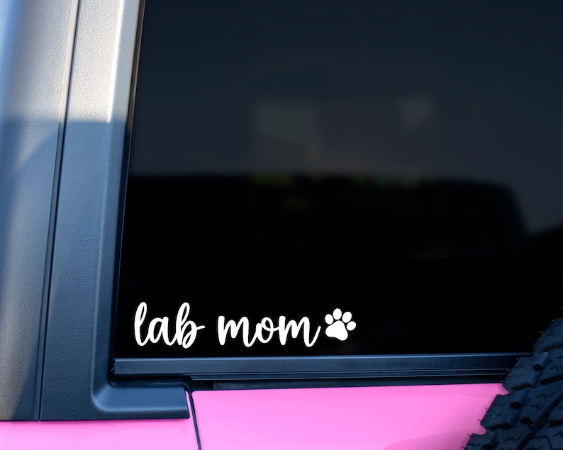 White Lab Mom decal with a paw print placed on the window of a car.