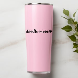 Black Doodle Mom decal with a paw print placed on a pink tumbler.