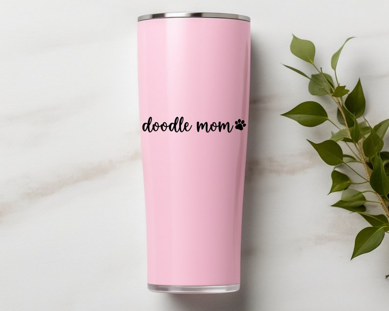 Black Doodle Mom decal with a paw print placed on a pink tumbler.