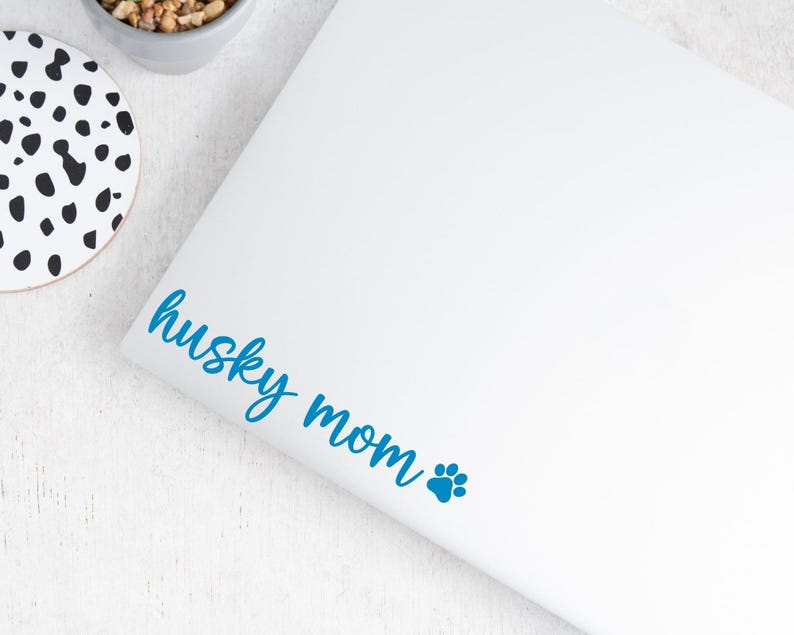 Blue Husky Mom decal with a paw print placed on a laptop.