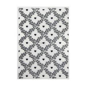 Puede incluir: Hoja de plástico transparente con un patrón repetitivo en blanco y negro de corazones y enredaderas florales. El patrón es un diseño repetitivo de corazones y enredaderas florales. La hoja es para usar con una máquina de manualidades.