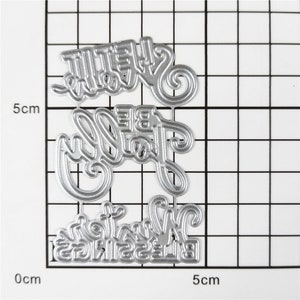 以下が含まれることがあります： スクラップブッキングやカード作り用の金属製ダイカット。ダイには「She'll Be Joy」と「Blessings Winter」の文字が刻まれています。