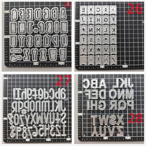 Może przedstawiać: Cztery arkusze metalowych szablon&oacute;w alfabetu do rękodzieła. Każdy arkusz zawiera inny zestaw liter i cyfr, a niekt&oacute;re arkusze mają elementy dekoracyjne, takie jak banery. Arkusze są oznaczone numerami 25, 26, 27 i 28.