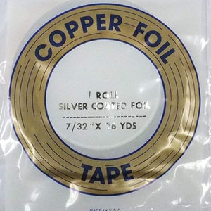 May include: A roll of 7/32 inch by 36 yard copper foil tape, silver coated. The tape is packaged in a clear plastic bag with a gold and blue label that reads "COPPER FOIL TAPE" and "I ROLL SILVER COATED FOR 7/32" X 36 YDS". The label also includes the text "MADE IN U.S.A.".