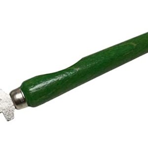 May include: A green handled glass cutter with a silver blade. The blade has multiple cutting edges and the text "DIAMANTOR GERMANY" is engraved on the blade.