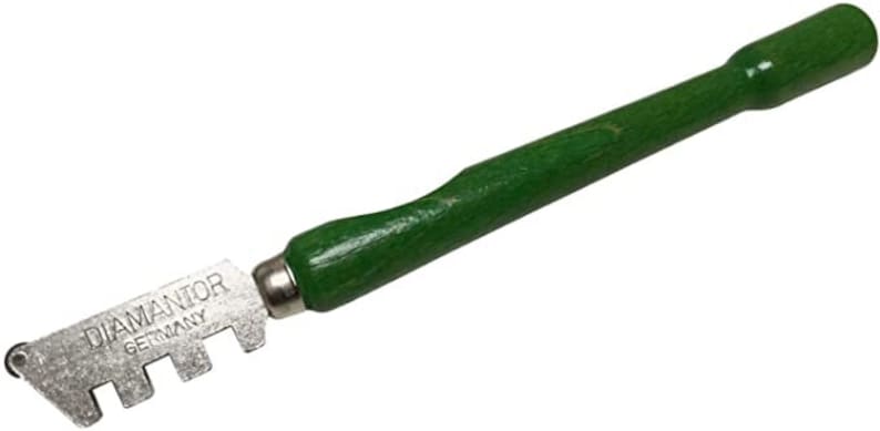 May include: A green handled glass cutter with a silver blade. The blade has multiple cutting edges and the text "DIAMANTOR GERMANY" is engraved on the blade.