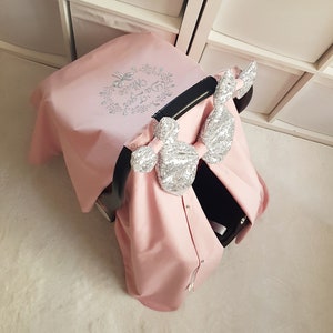 ブラッシュピンクのカスタムカーシートカバー ベビーガール、パーソナライズベビーカーシートキャノピー 3 シルバースパンコールリボンと花の名前刺繍付き